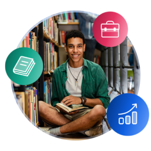 A male international student wearing summer clothing sits cross-legged on the floor of a campus library, holding a book.
