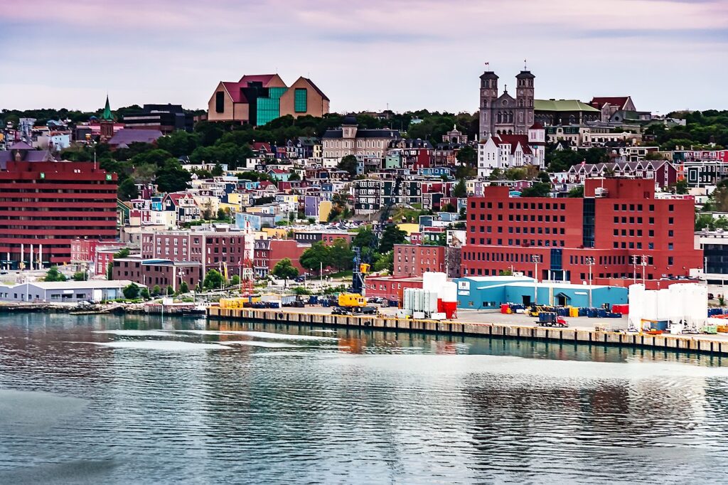 A view of St. John's from the harbour: colourful houses rise up a seaside hill