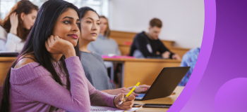 International students sit in a well-lit classroom in tiered seats.